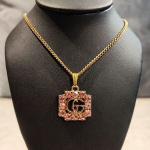 GUCCI GG GOLD TONE PENDANT WITH PINK RHINESTONE ACCENTS ON GOLD PLATED NECKLACE